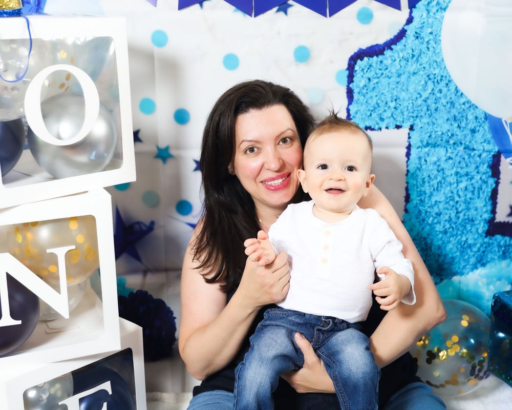 Blue and white first birthday photo setup with decorative blocks and stars.