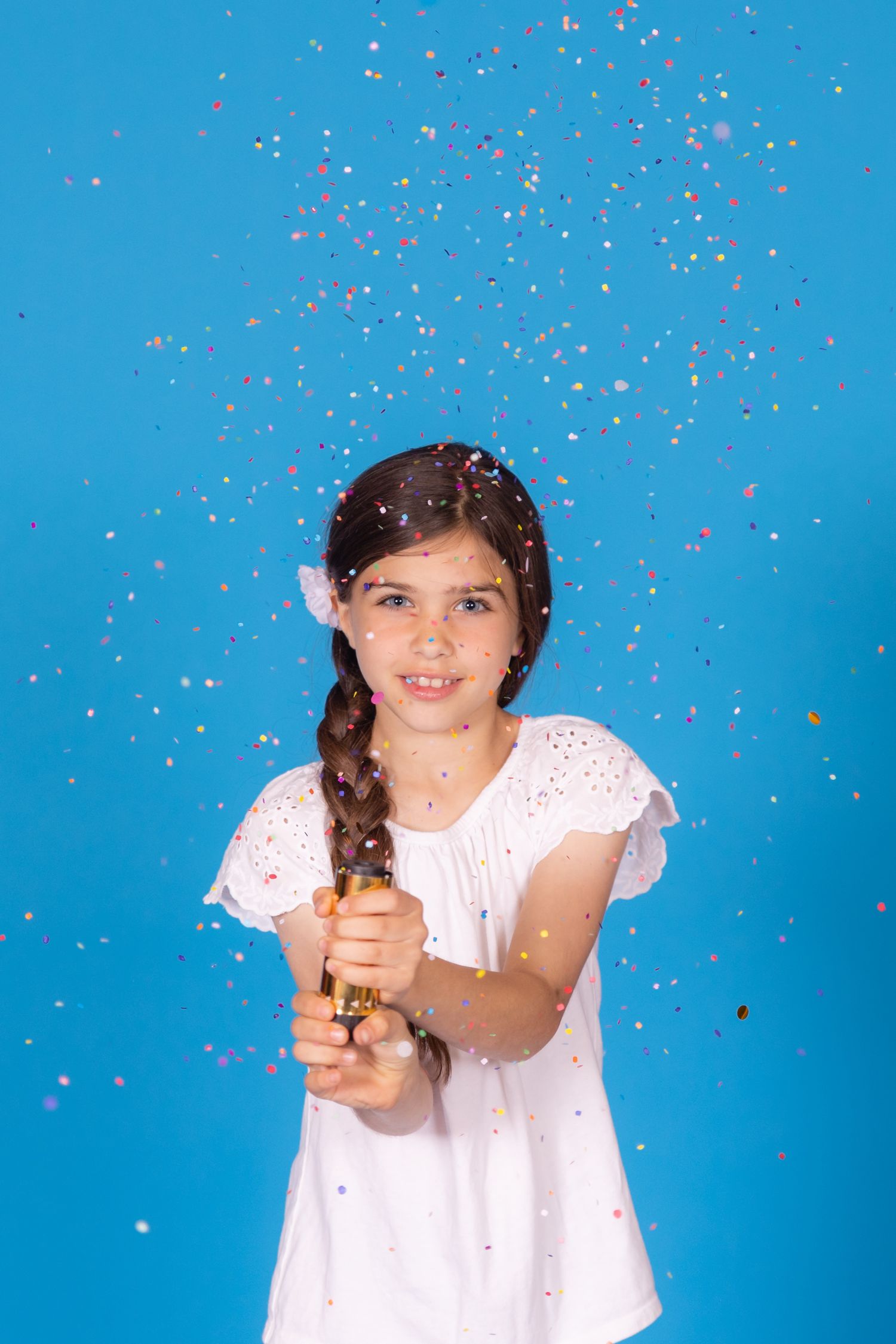childing popping confetti cannon on savage blue jay backdrop in studio in clayton new jersey gloucester county