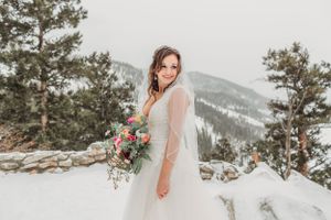 Bride poses with her bouquet in the mountains in Breckenridge, CO.