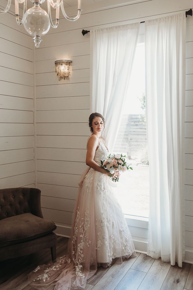 Bride poses next to a window full of light in Houston, TX.
