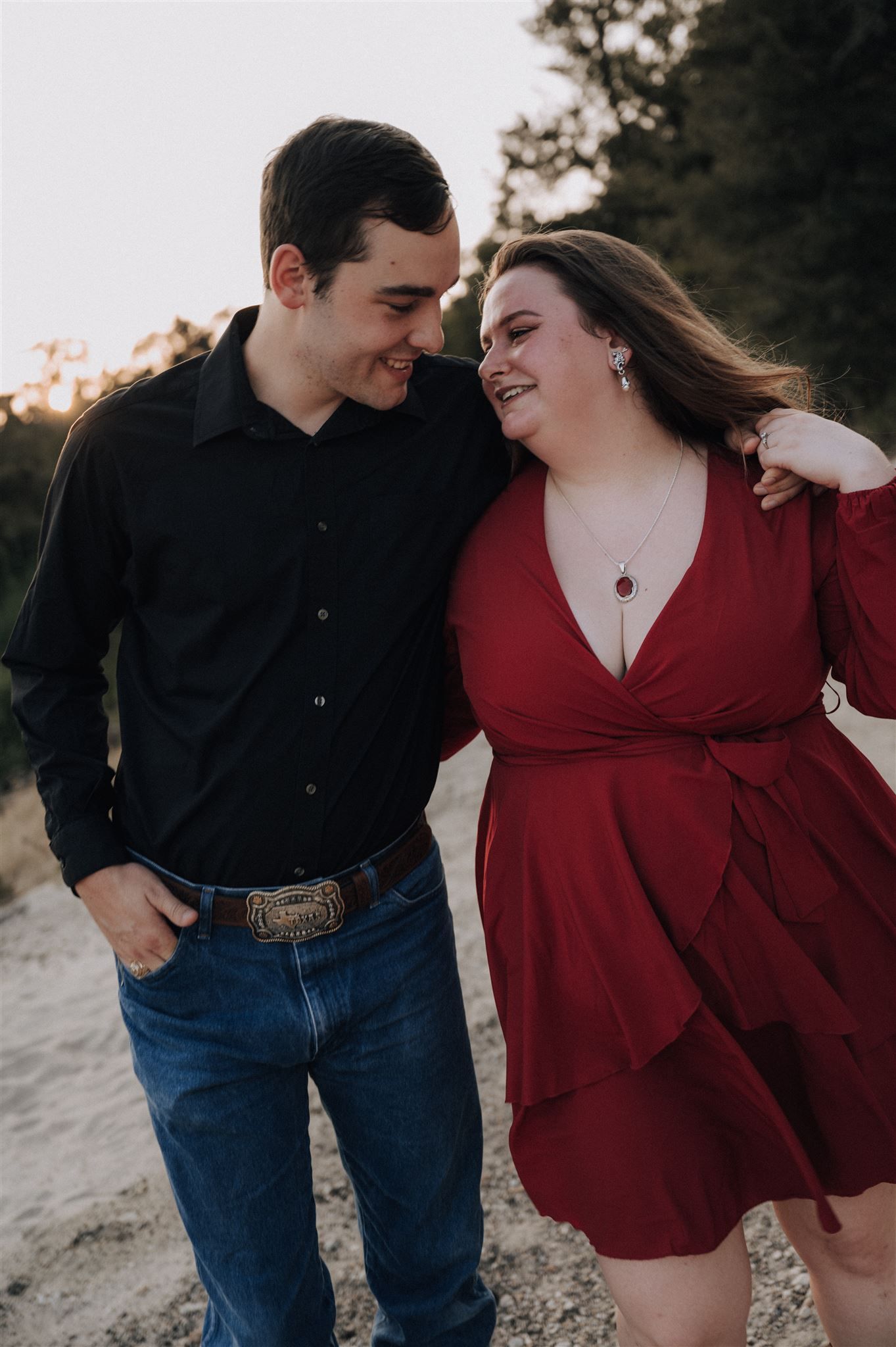 A happy couple shares a laugh together during an outdoor photoshoot.