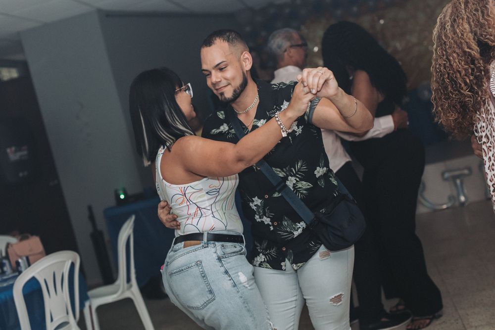 People dancing together at a dimly lit indoor party or celebration.