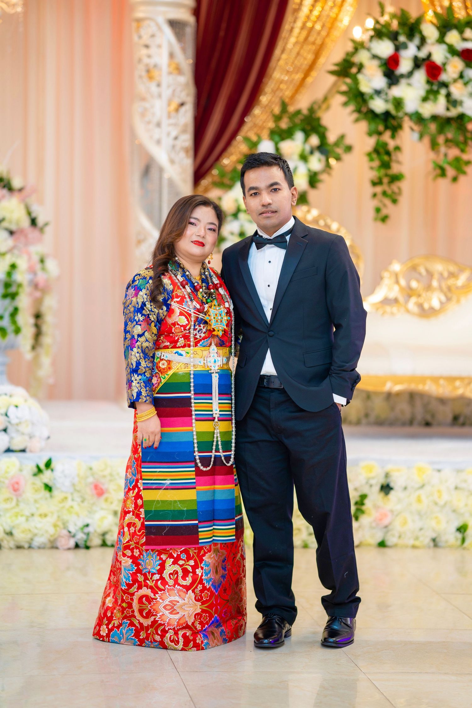 Formal portrait of couple in traditional Nepali dress and western suit.