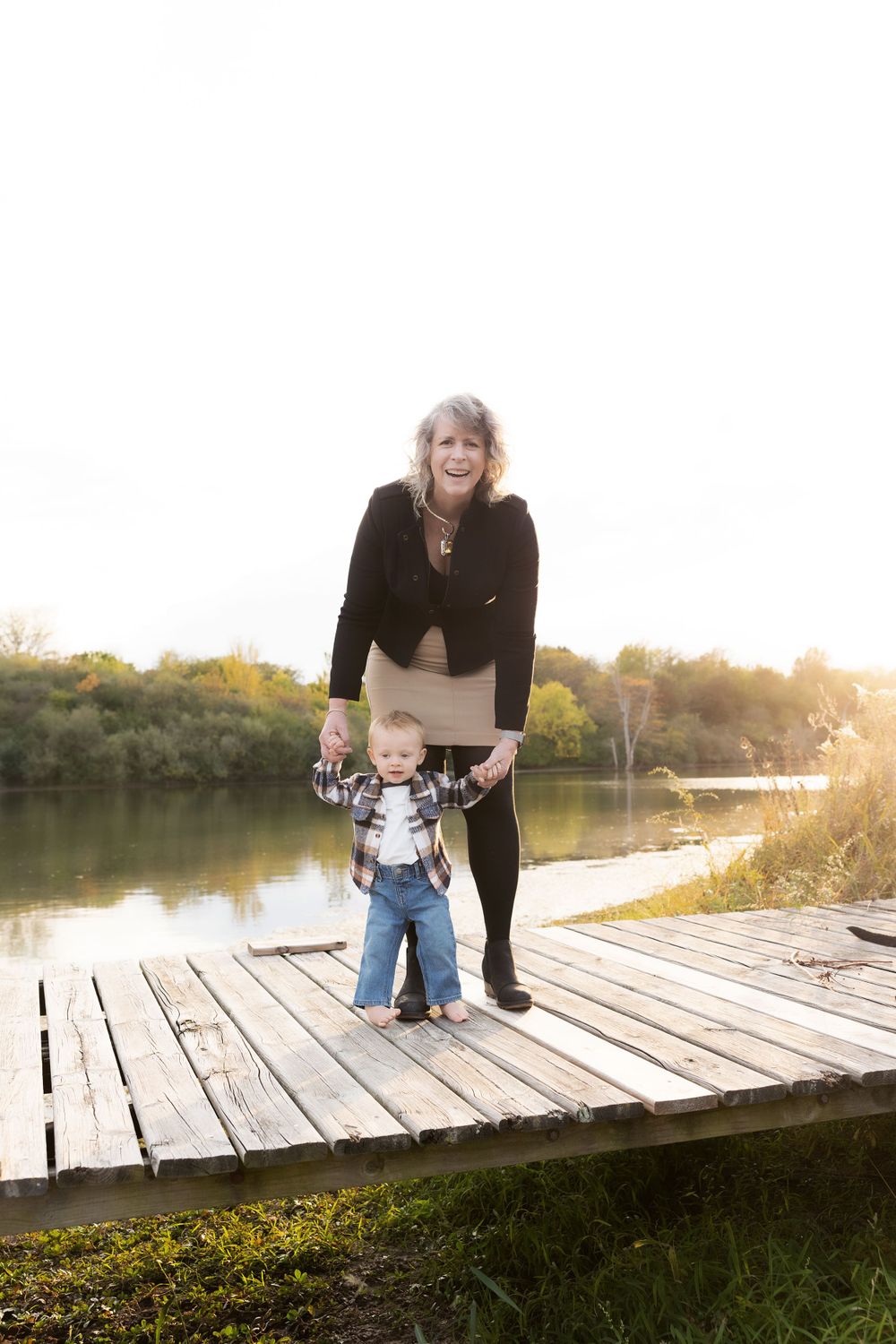 Two people share a special moment standing on a wooden dock during golden hour.