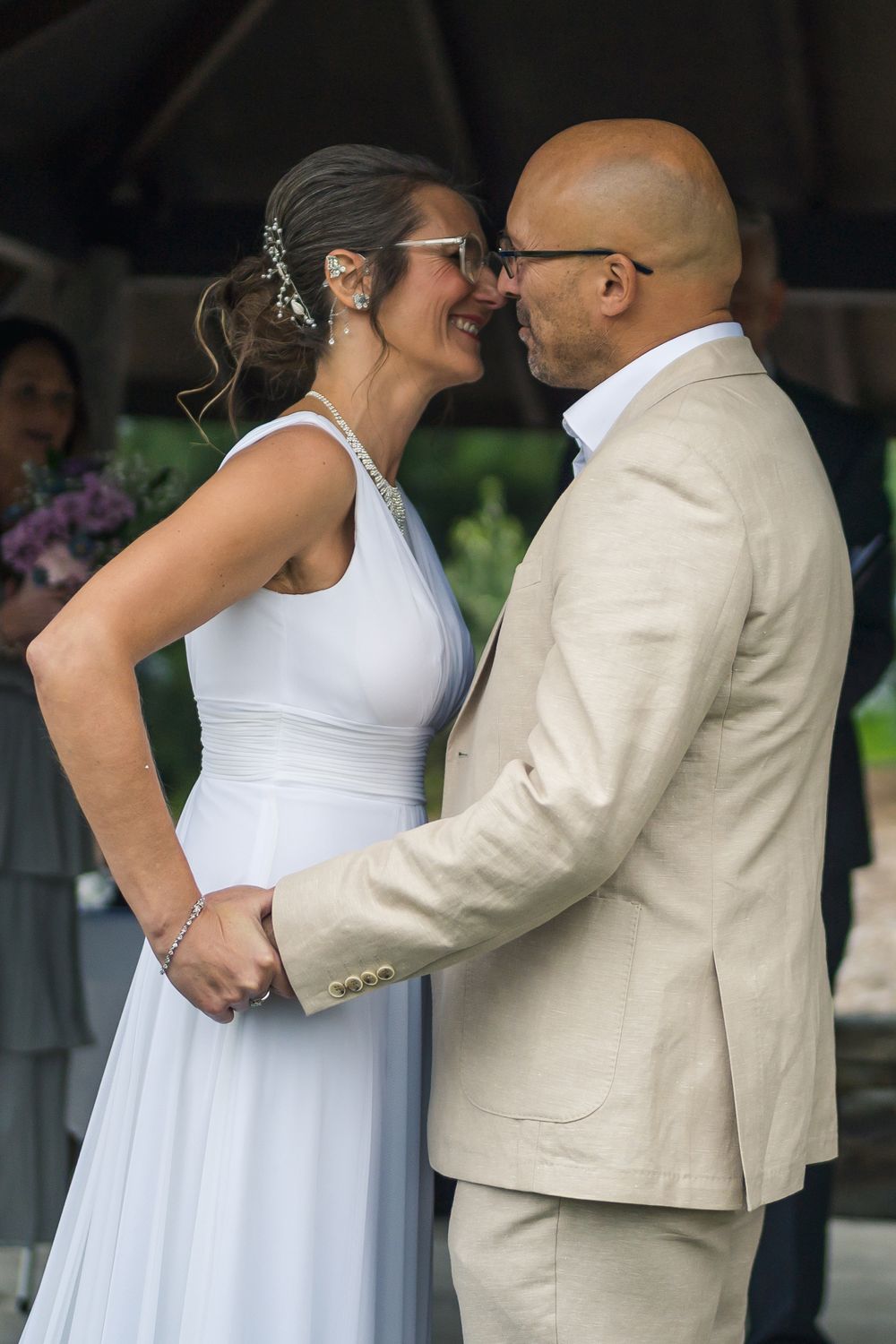 casually dressed mature bride and groom embrace during first kiss at bellarine wedding
