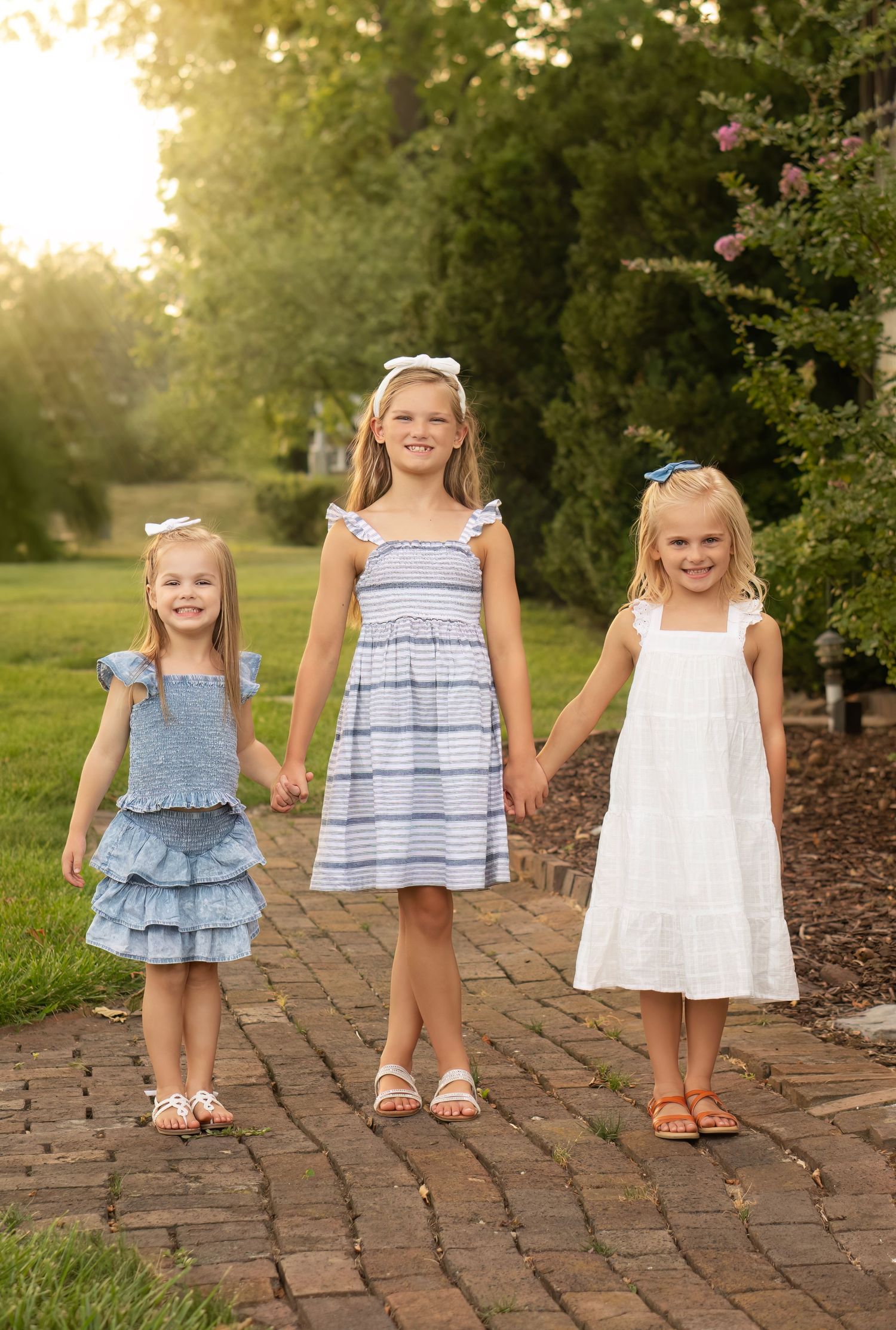 sisters hold hands in outdoor portrait