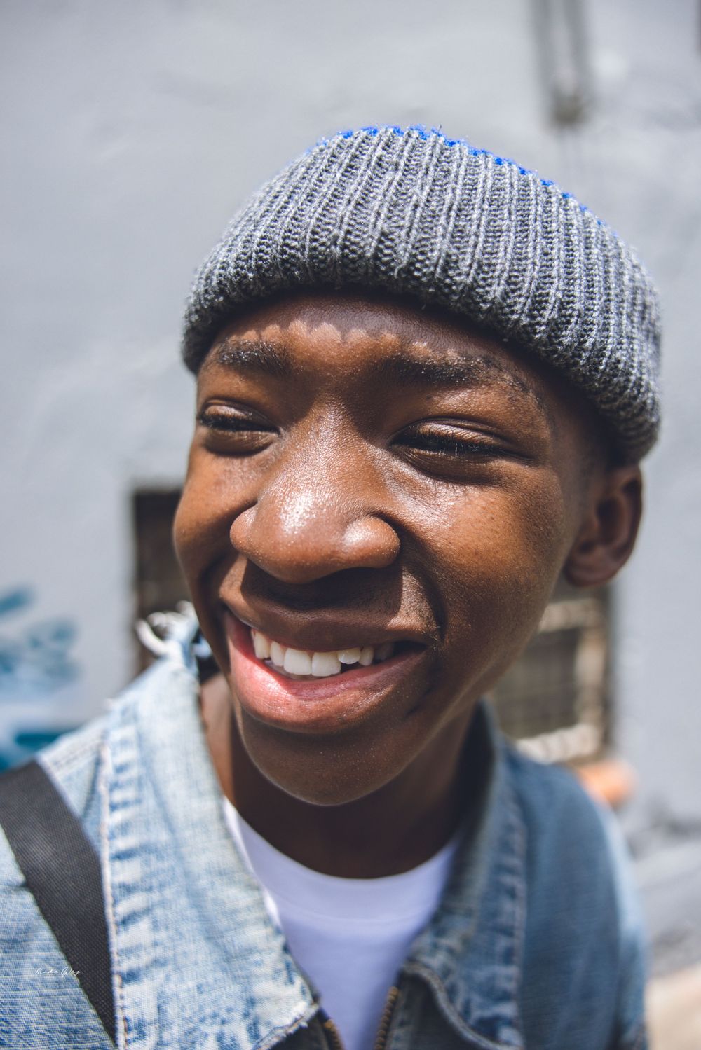 Progressive shots of someone in a knit beanie and denim showing natural expressions.