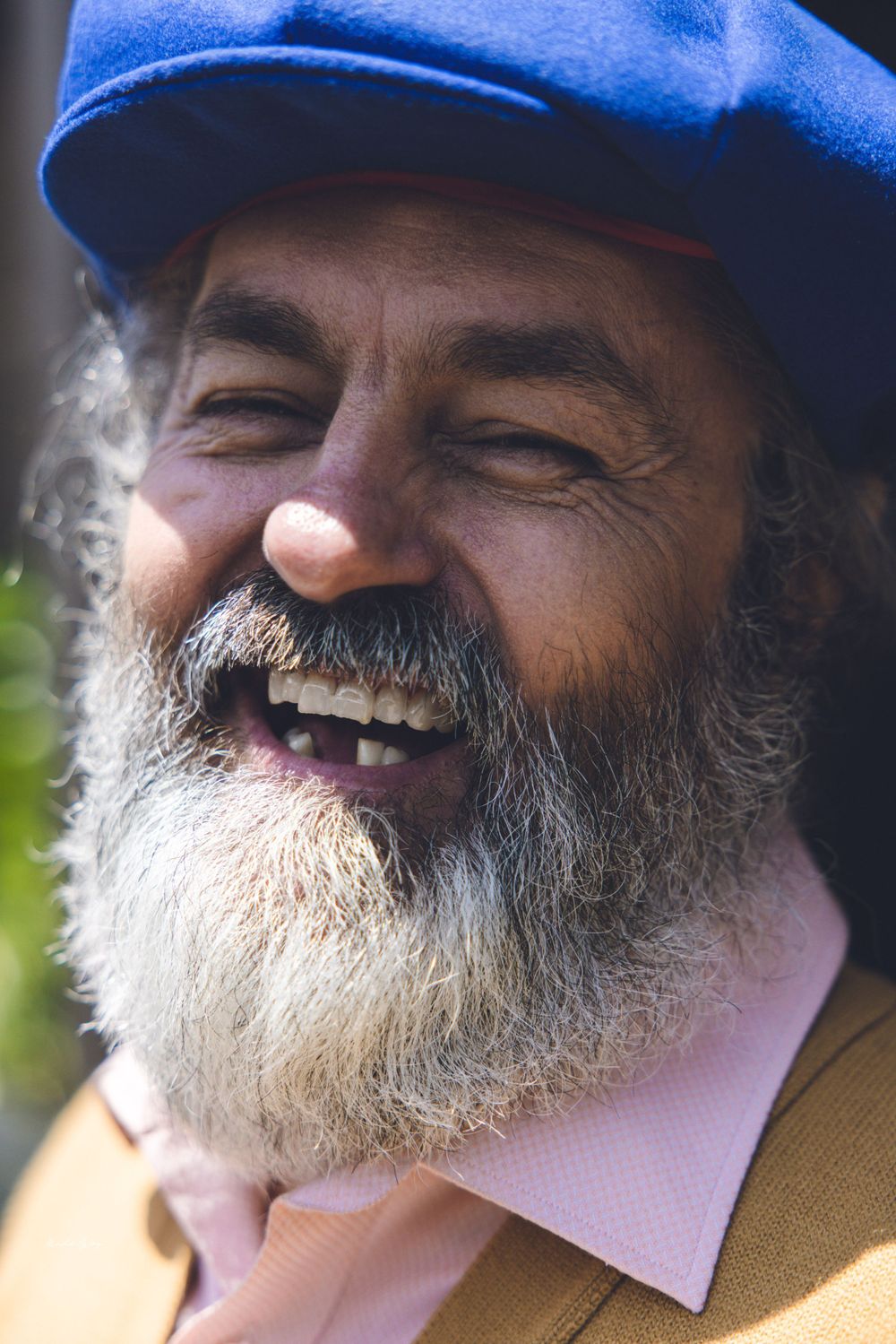 Close-up shots of someone in a blue cap with a gray beard expressing joy.