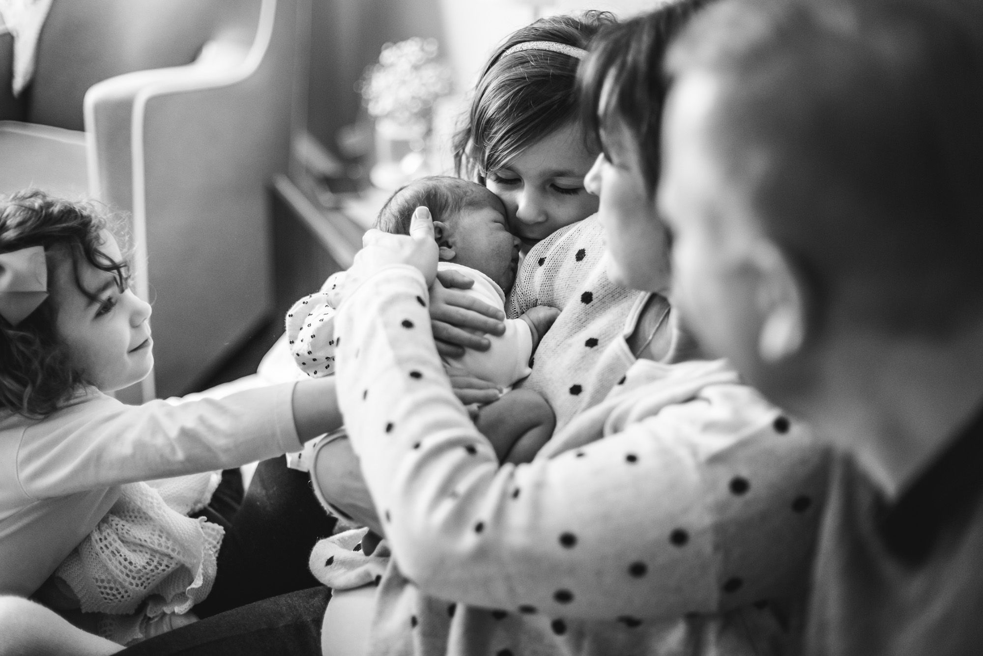 A young family gathers around mom as she holds their newest addition.