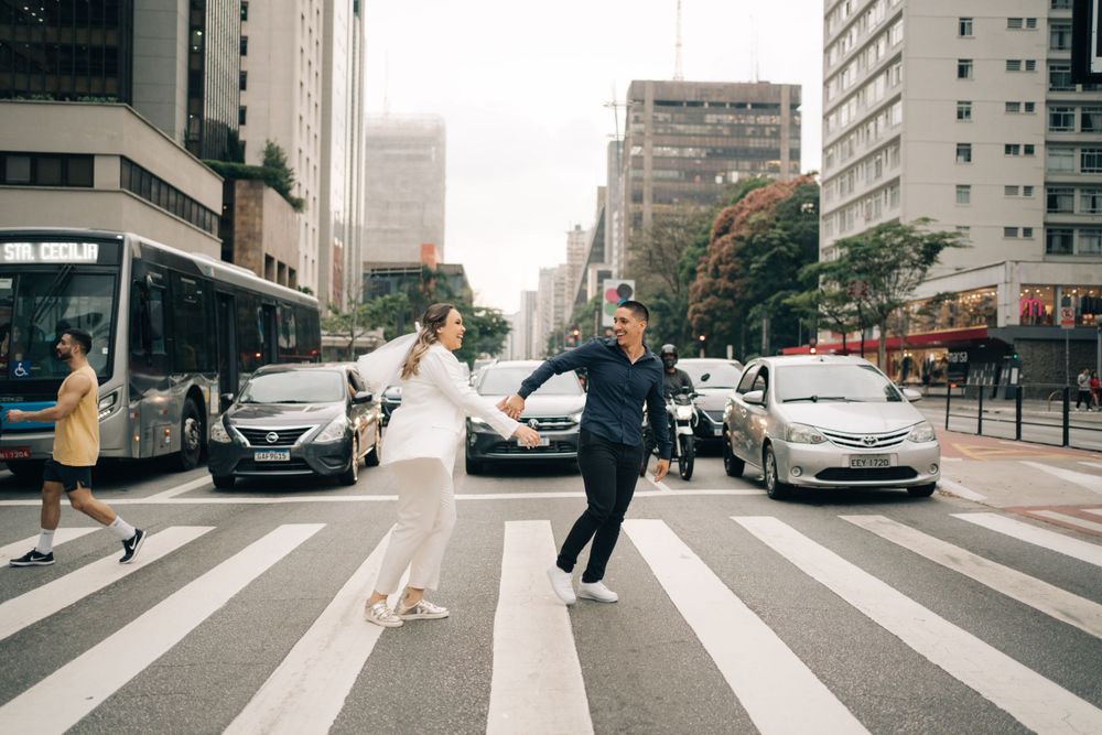 ensaio pré wedding urbano com casal atravessando a Avenida Paulista em um cenário metrópole, destacando estilo de fotografia documental