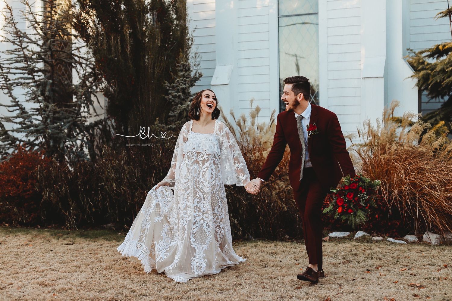 A candid wedding moment showing movement and joy outside a light blue church.