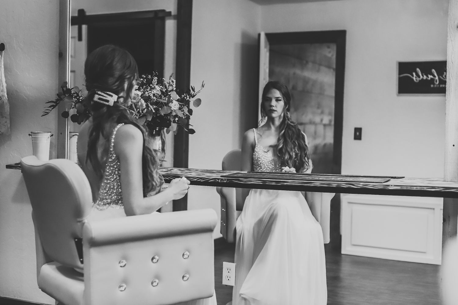 Black and white photo of two people getting ready in a bridal suite.
