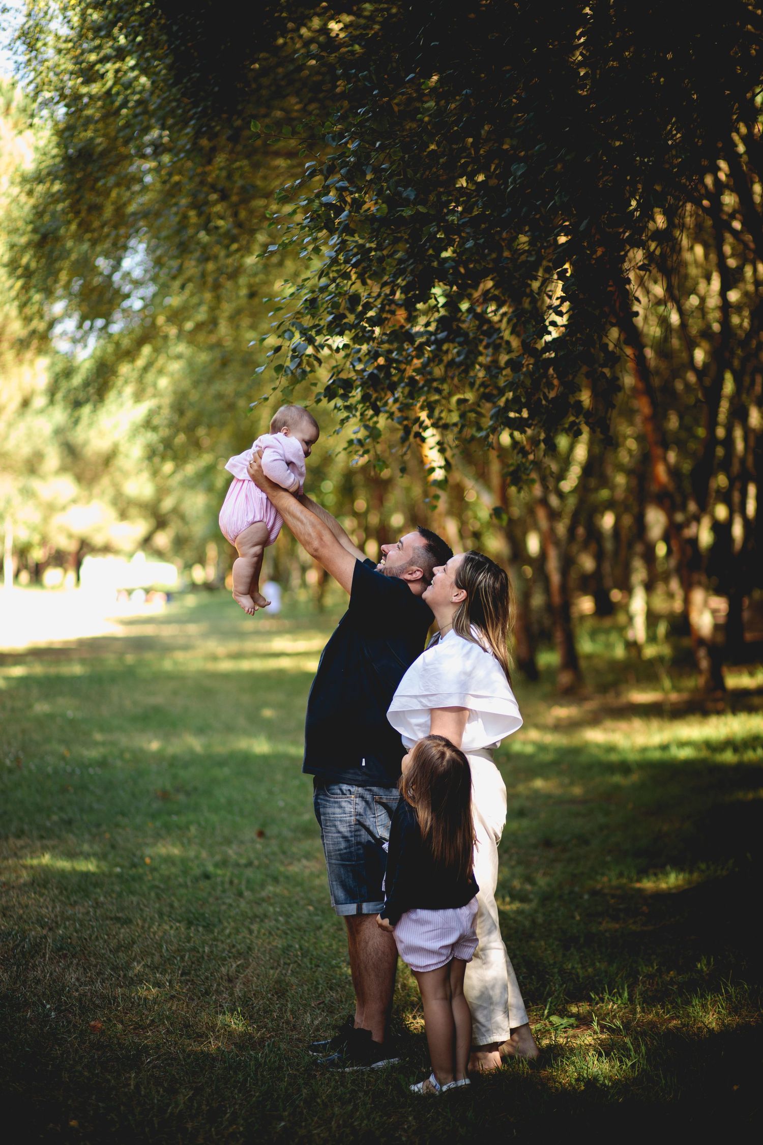 Fotografia de família no Parque da Cidade do Porto, família com pai, mãe, e as duas filhas, a mais nova uma bebé