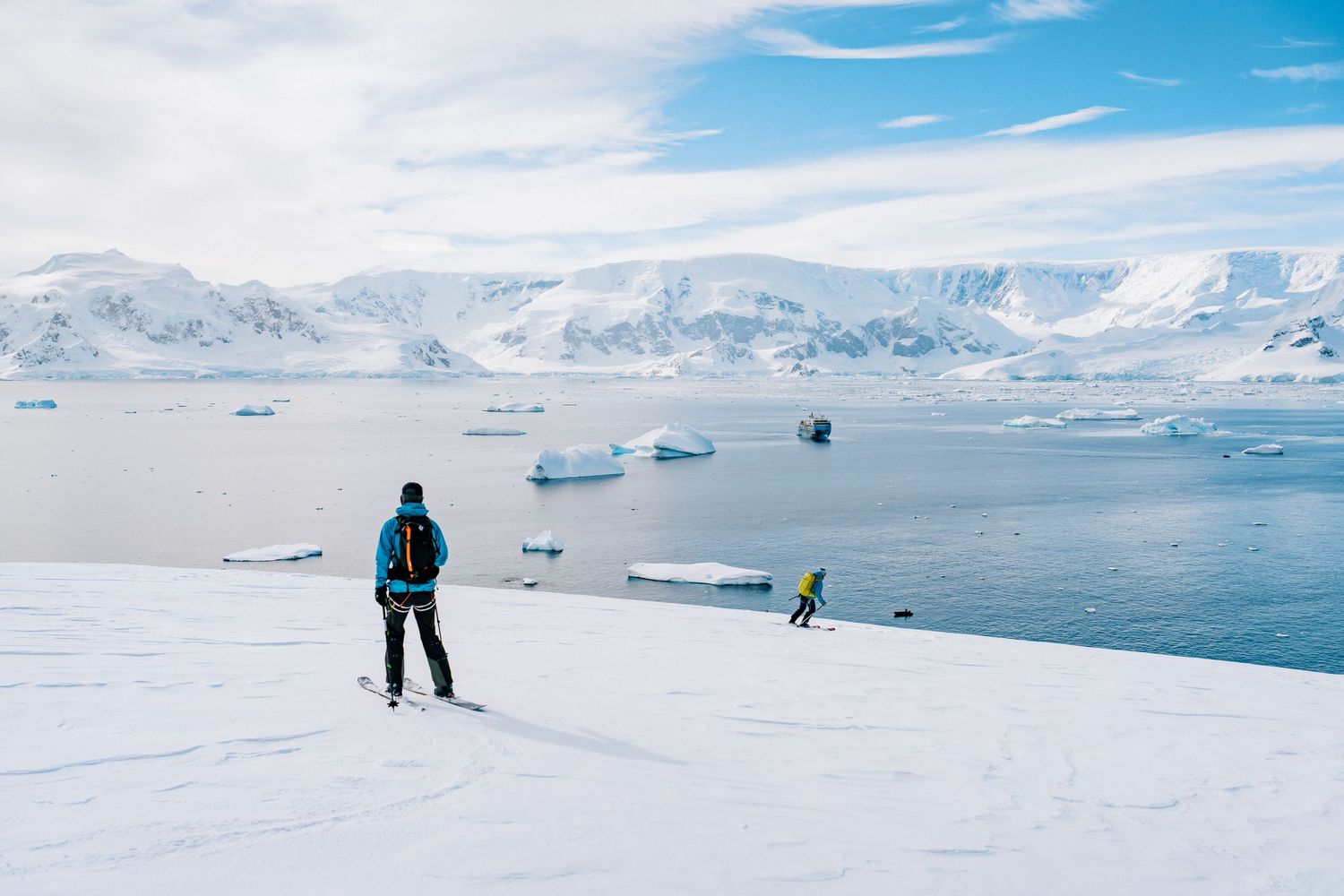 Skiers traversing a vast snowy expanse in Antarctica