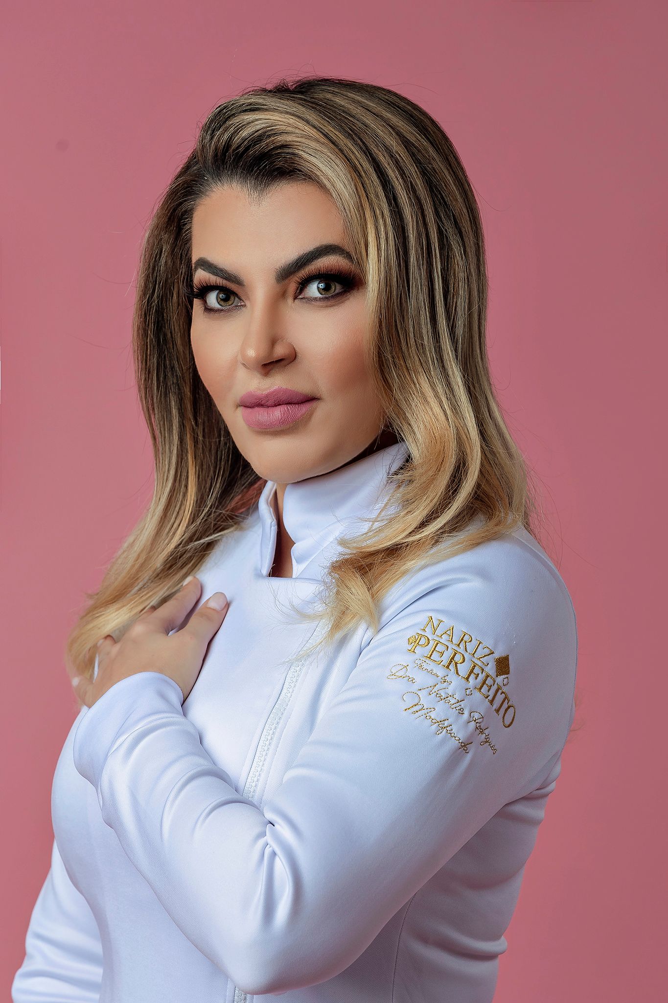 Close-up shot showing a white zip-up jacket with gold embroidered detail.
