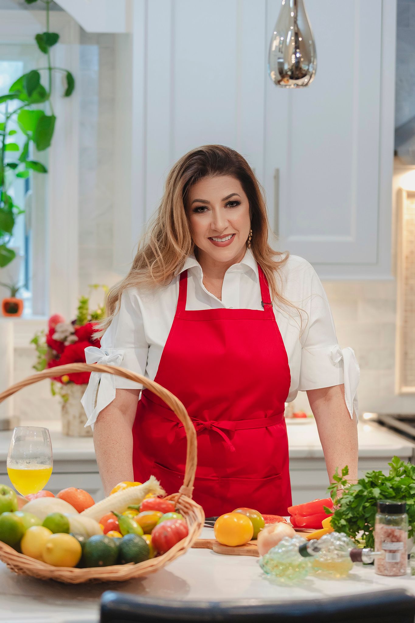 A bright kitchen setting with a red apron and fresh produce displayed on a counter.