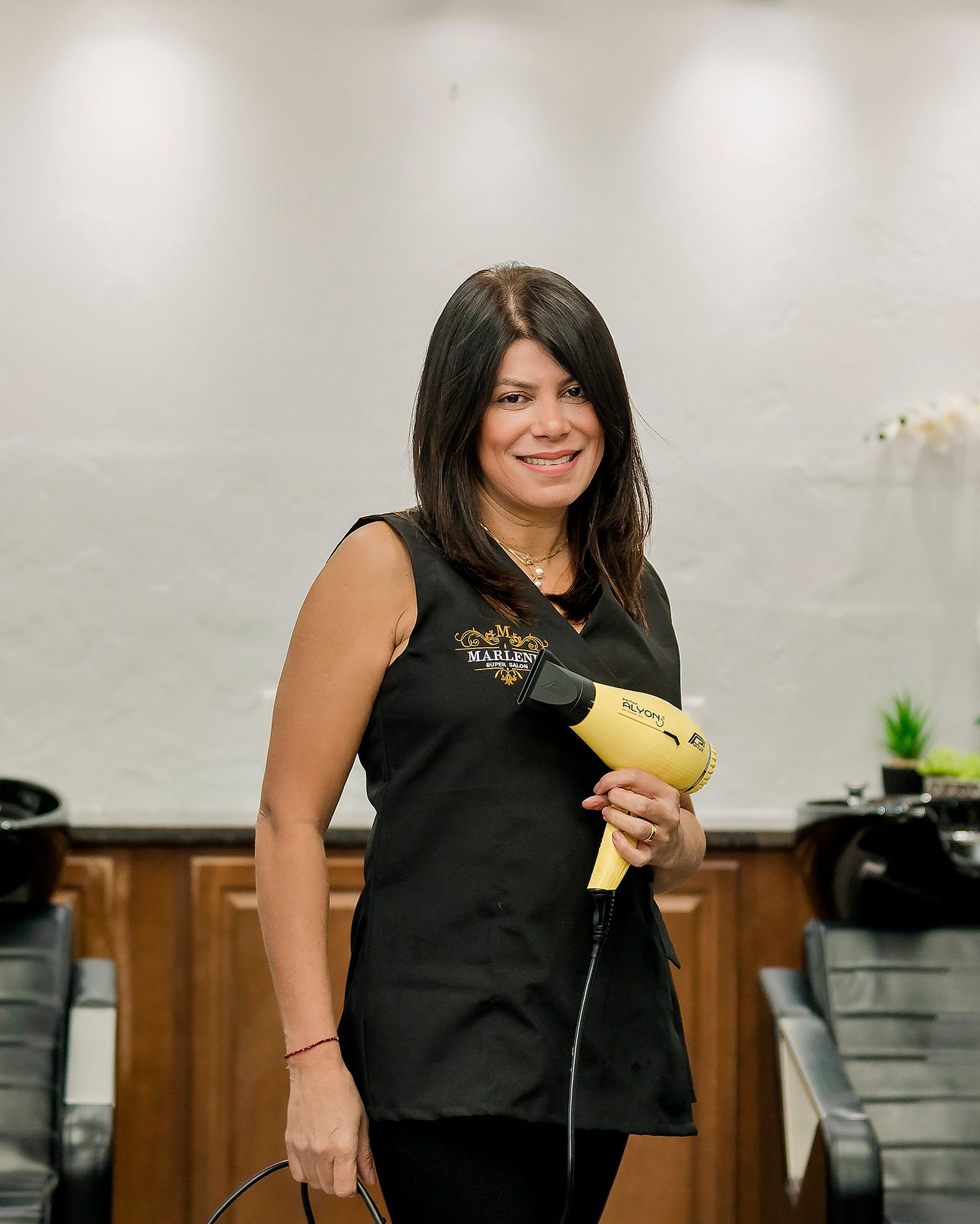 Woman in black uniform holding yellow phone in professional office setting.