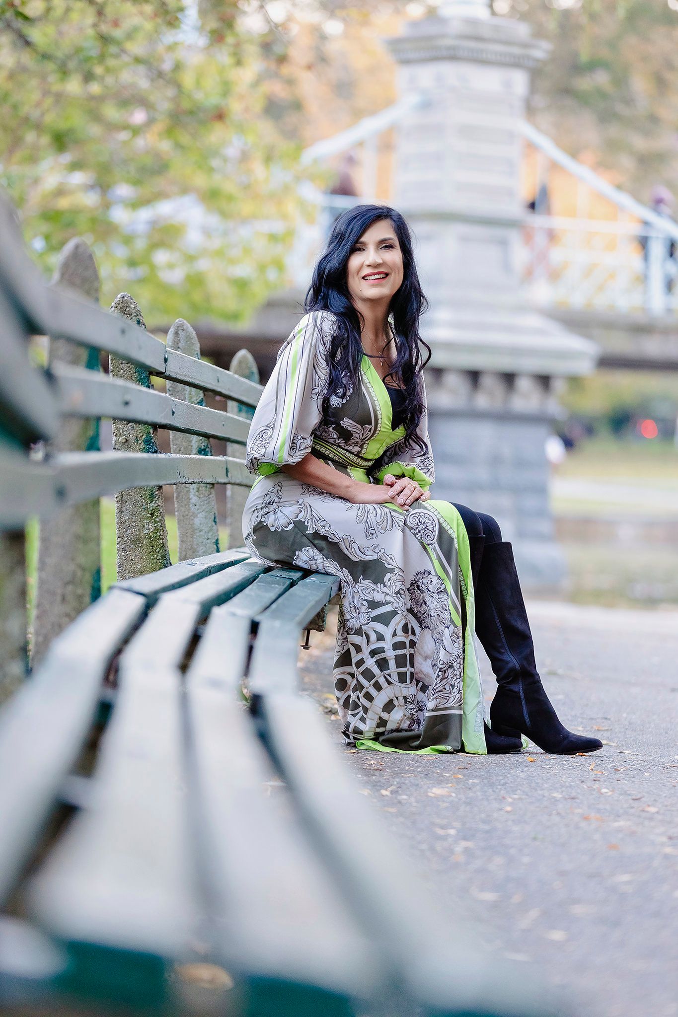 Outdoor portrait on park bench with Gothic architecture in background.