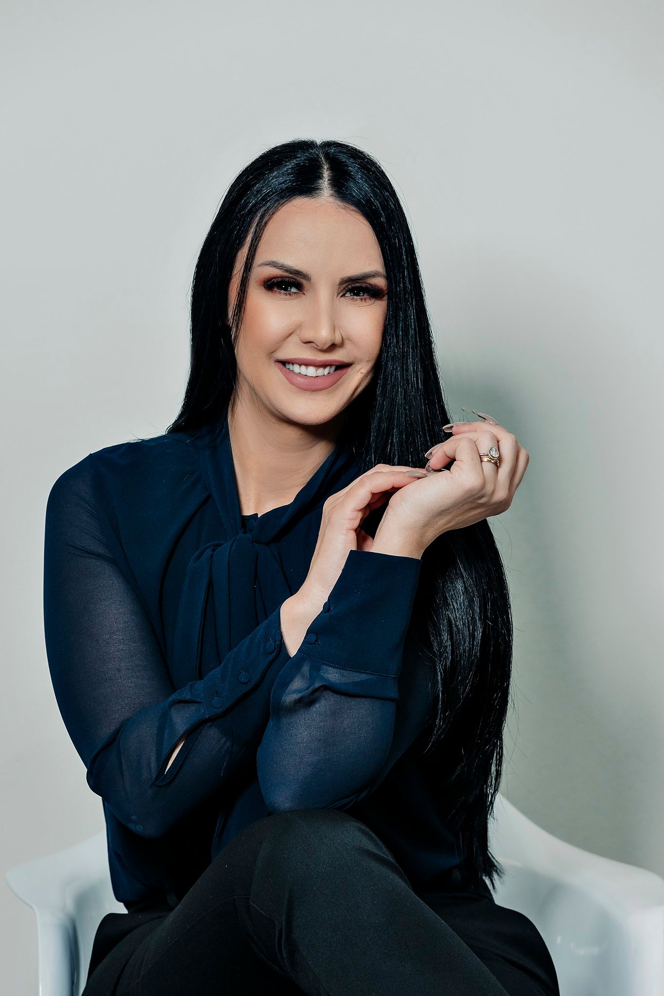 Professional headshot in navy blouse against light background.