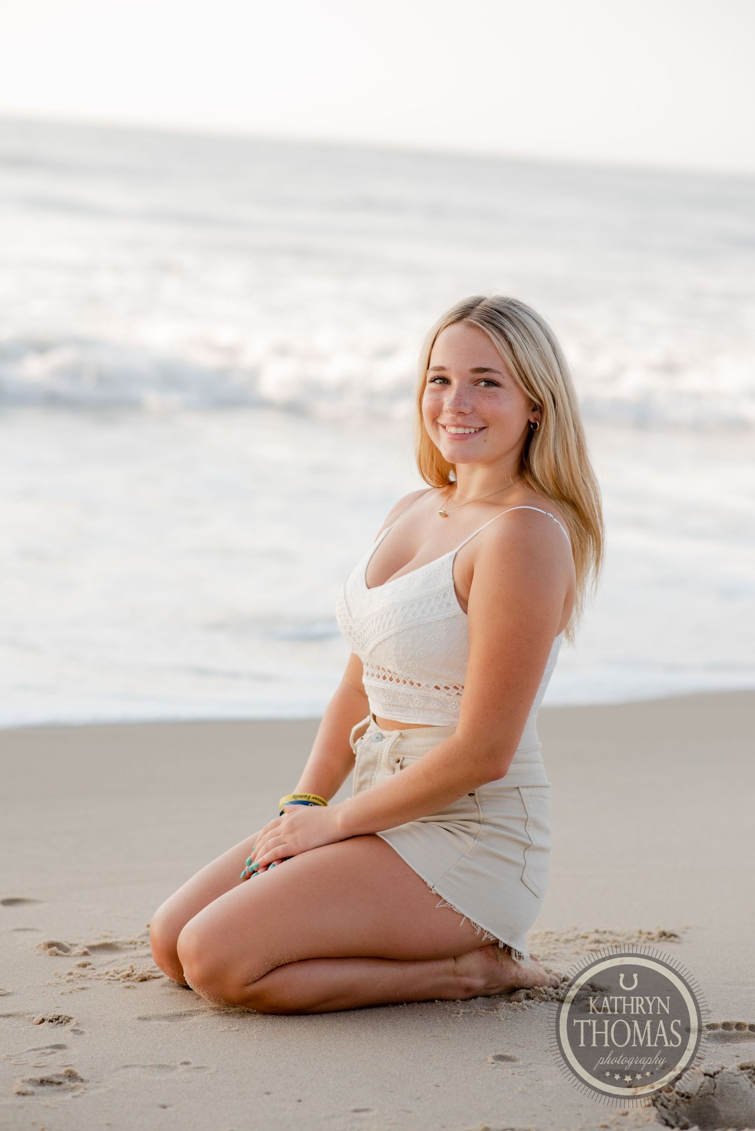 Seaside portrait at sunset with gentle waves and sandy beach in the background.