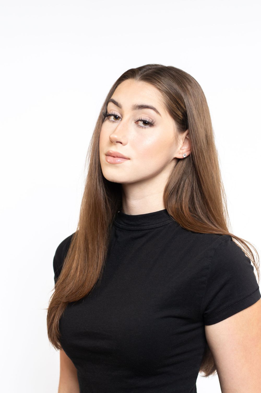 Close-up beauty portrait showcasing long brown hair and black turtleneck top.