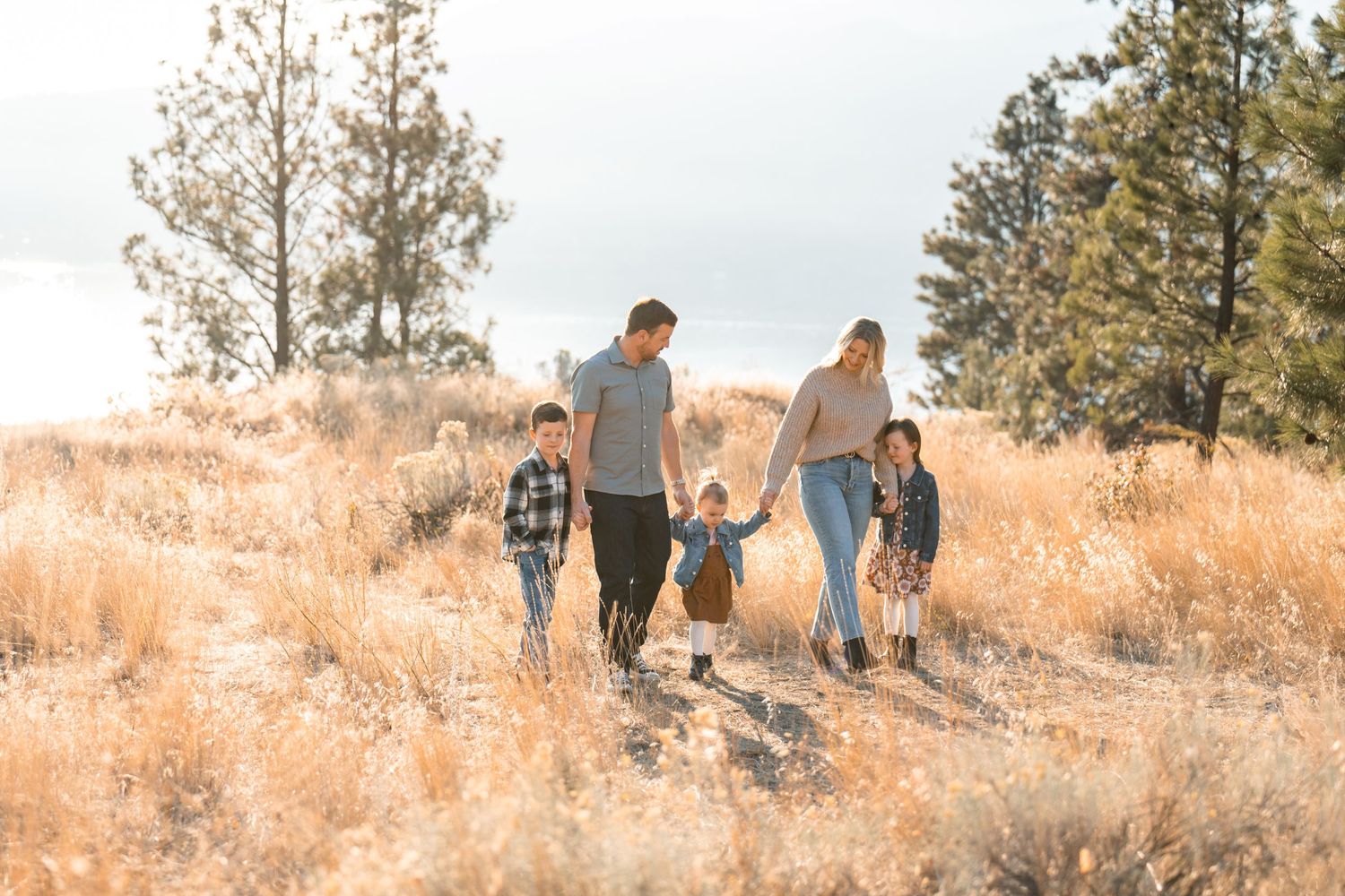 Family of 5 walking together holding hands on mountain with golden light photo taken by Pelka Photography Alicante Spain