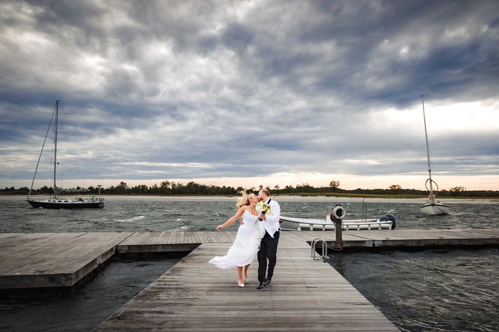 Stepping off their boat on Boston Harbor, the bride and groom share a quick kiss before their wedding reception