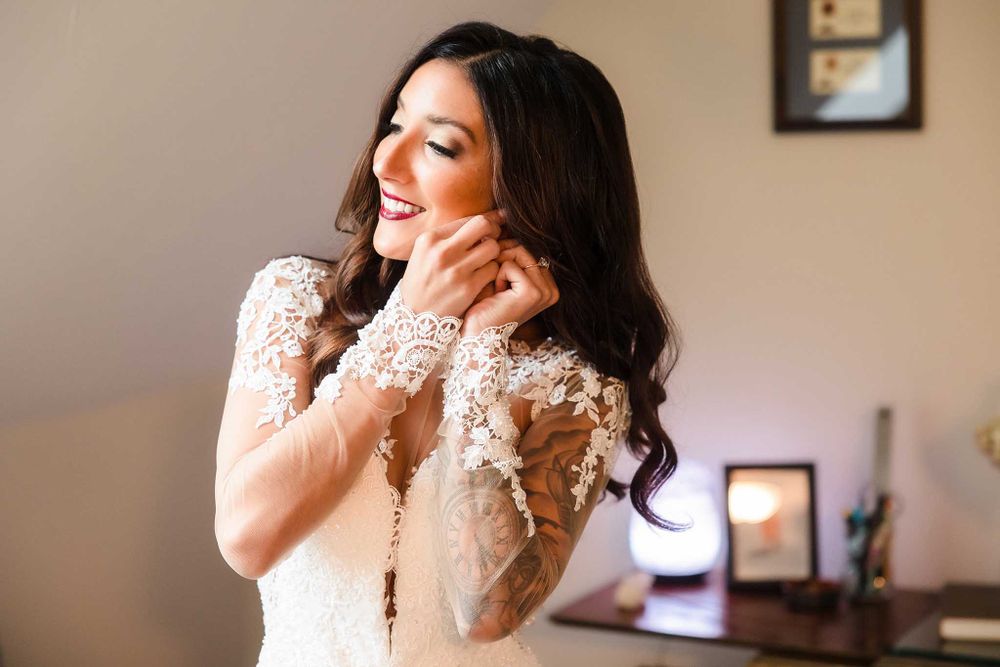 The bride puts on her ear rings while getting ready for her wedding