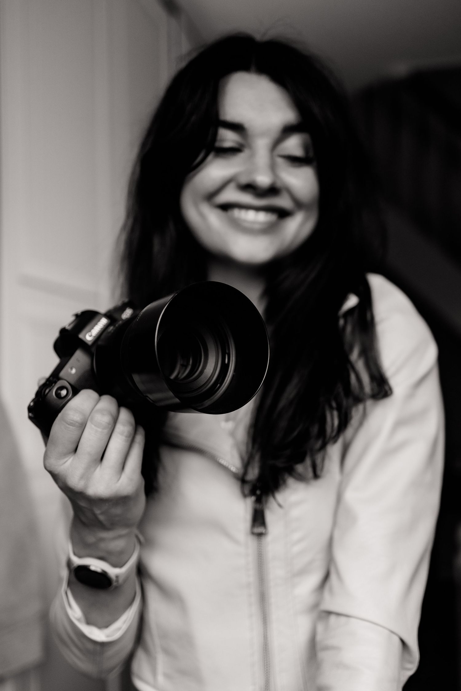 Candid black and white photo of photographer with camera in natural light.