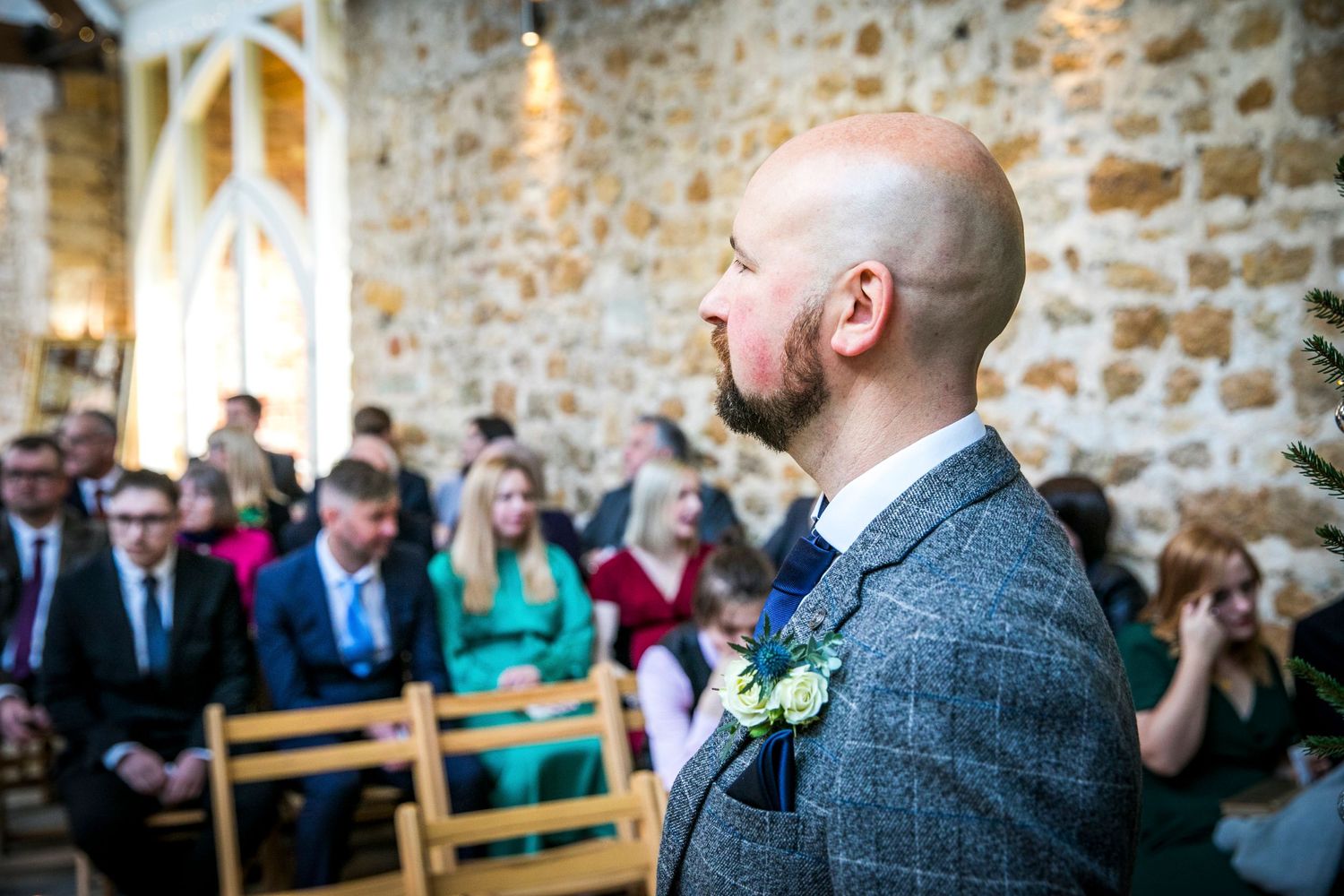 Wedding ceremony in a rustic venue with exposed stone walls and natural lighting.