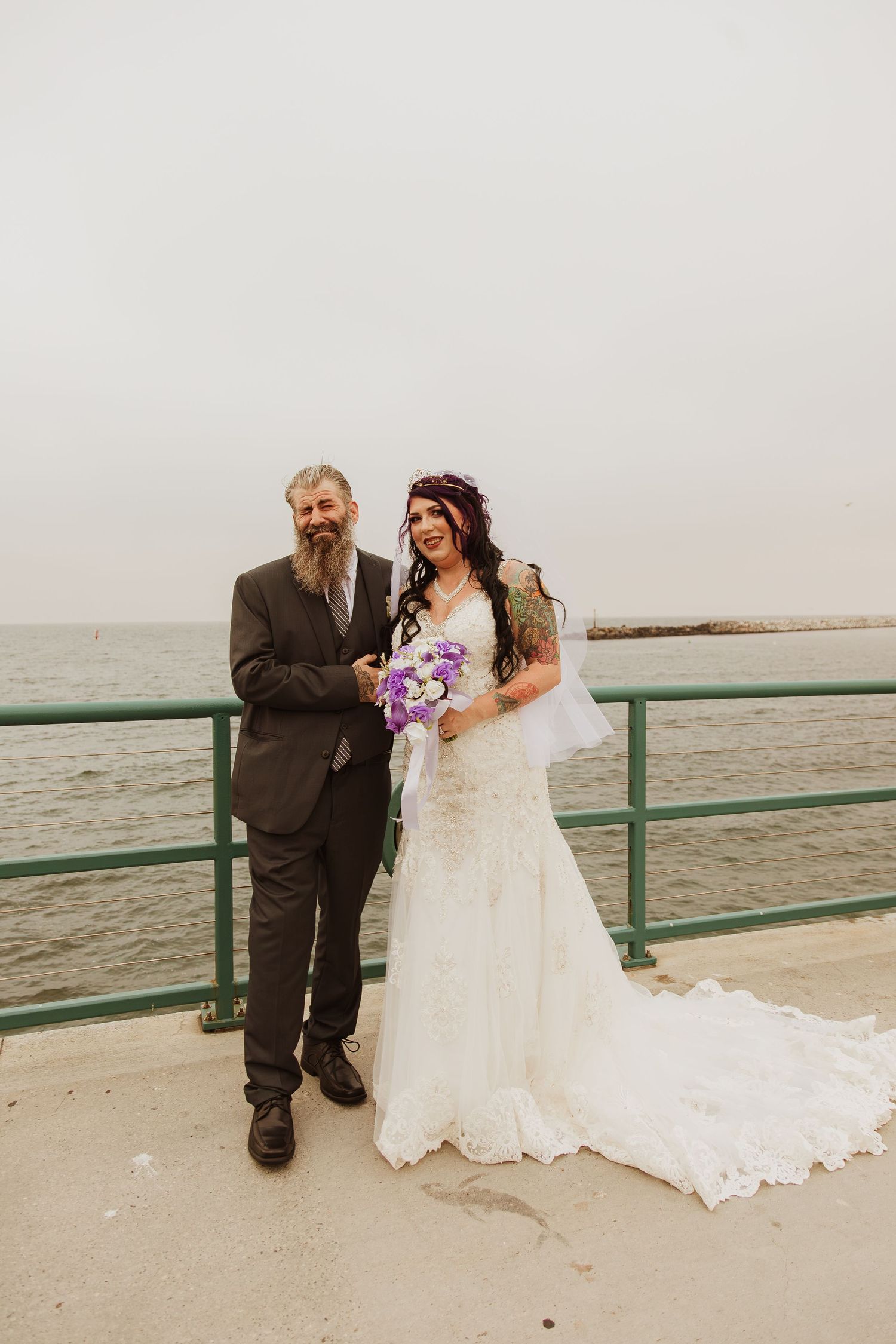 A scenic beachside wedding portrait with the ocean in the background.