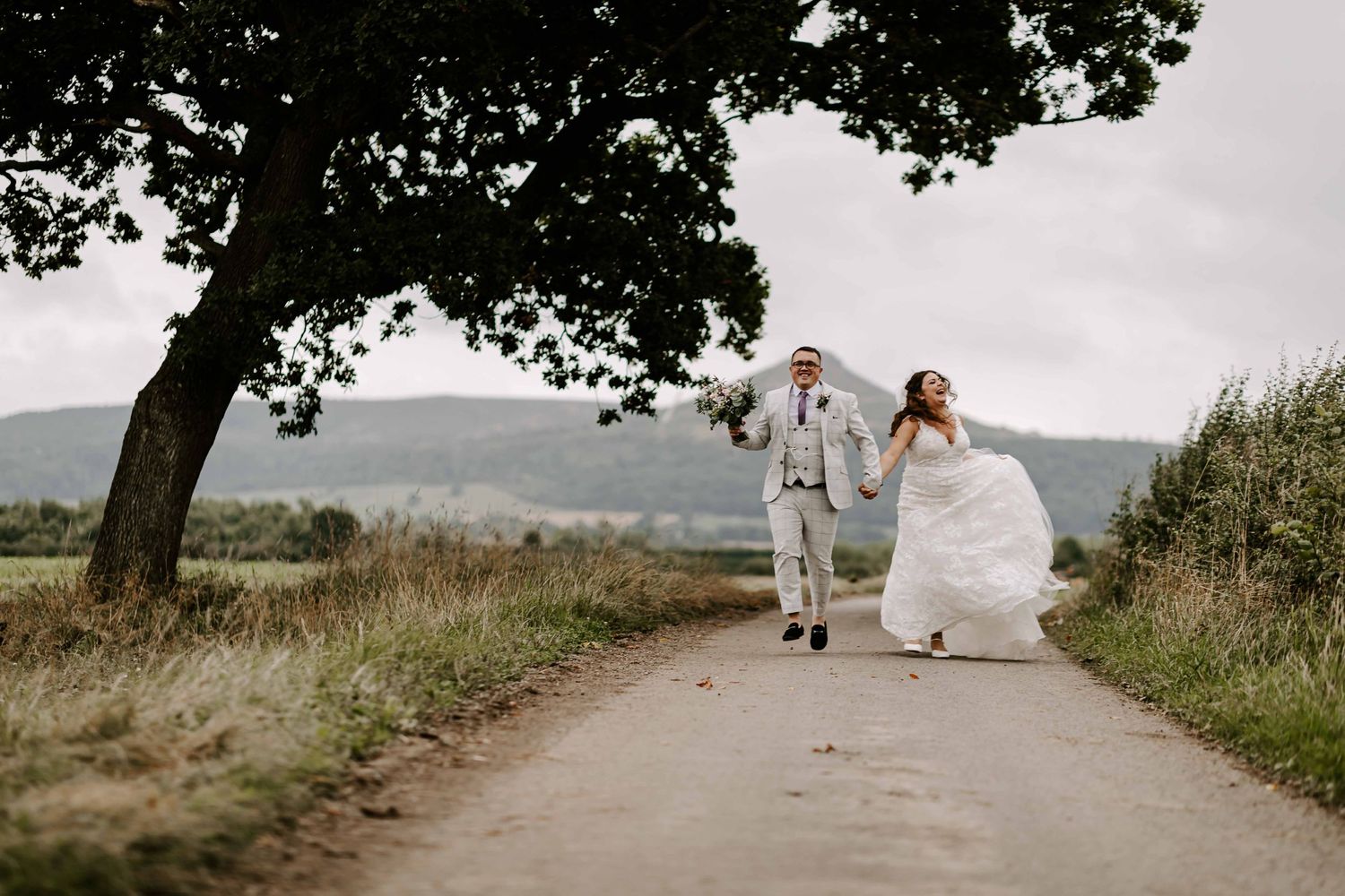 Wedding couple skipping at Roseberry Topping view, from Treebridge Hotel