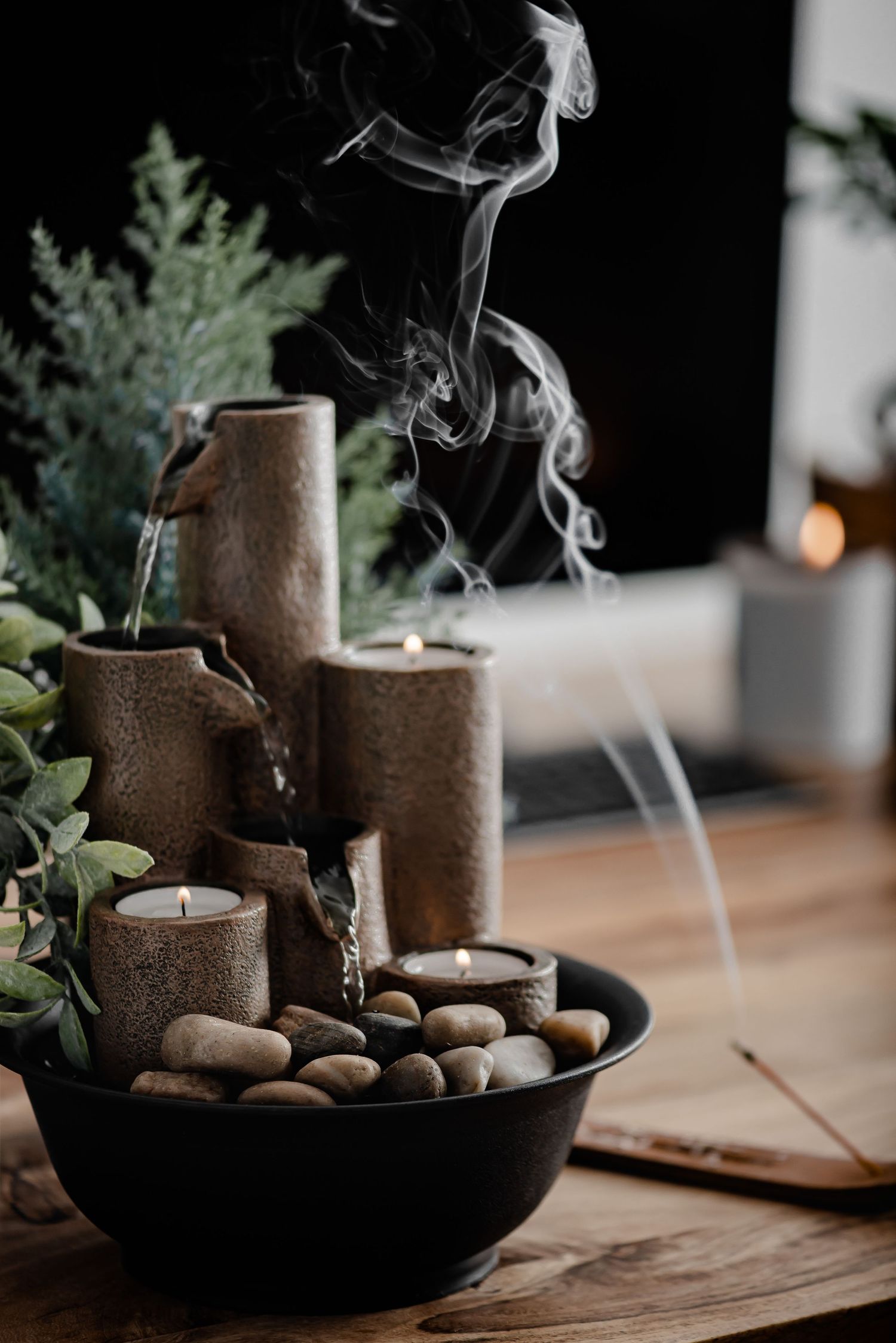 Small water feature with candles on desk and burning incense behind. Soothing, relaxing, zen
