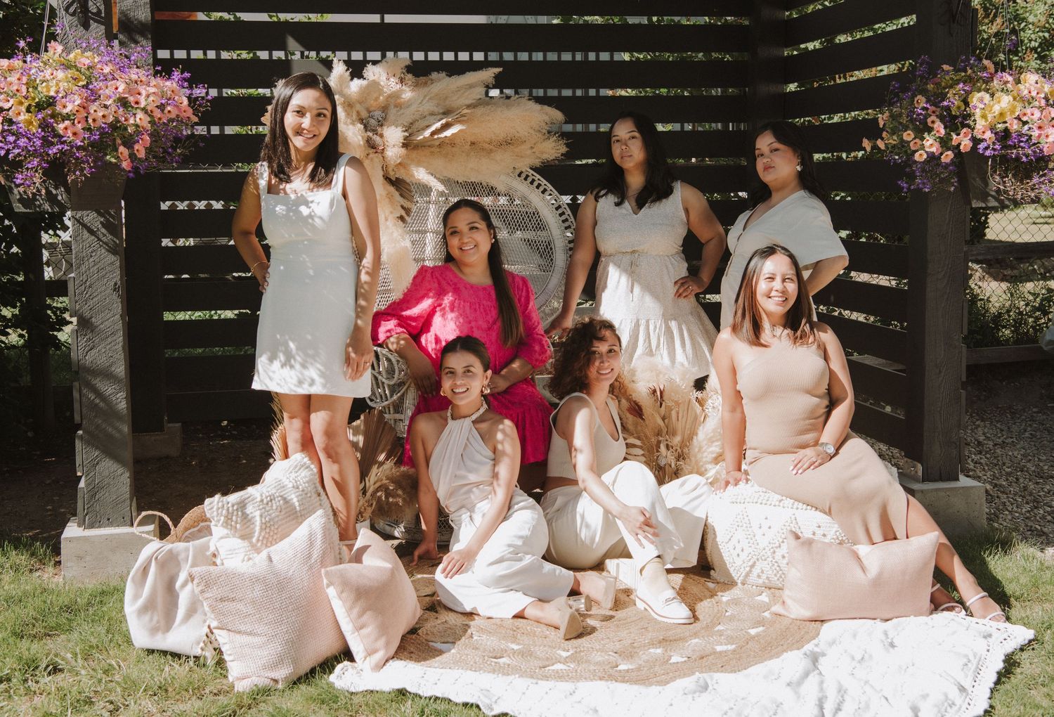 A group sits on picnic blankets for an elegant outdoor garden party with floral decorations.