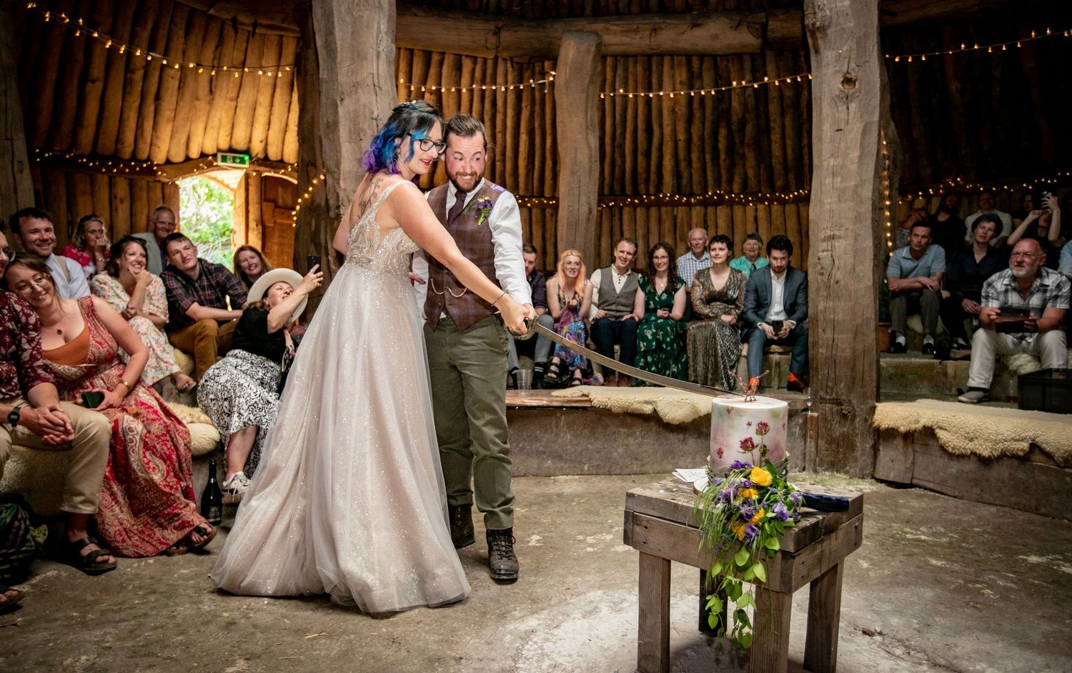 Rustic barn wedding reception with string lights and dancing guests creating a festive atmosphere.