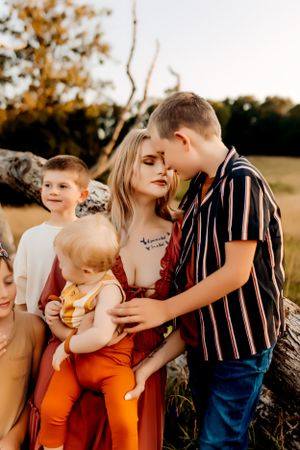 Family portrait during golden hour in rustic outdoor setting.