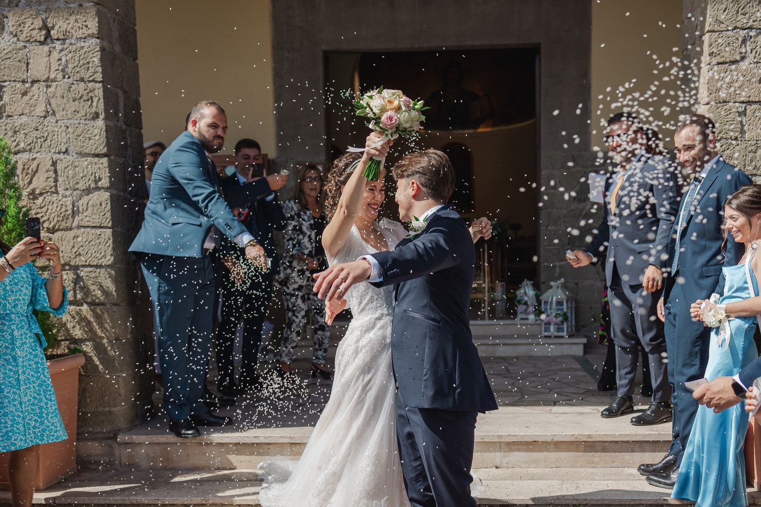 Joyful celebration with confetti shower outside church entrance.