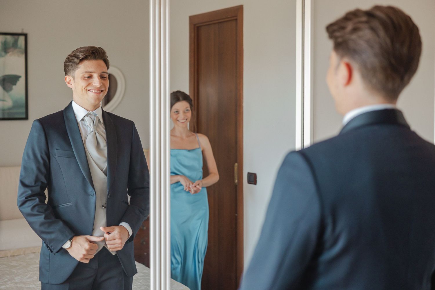 A formal scene with reflections in a mirror and elegant attire.