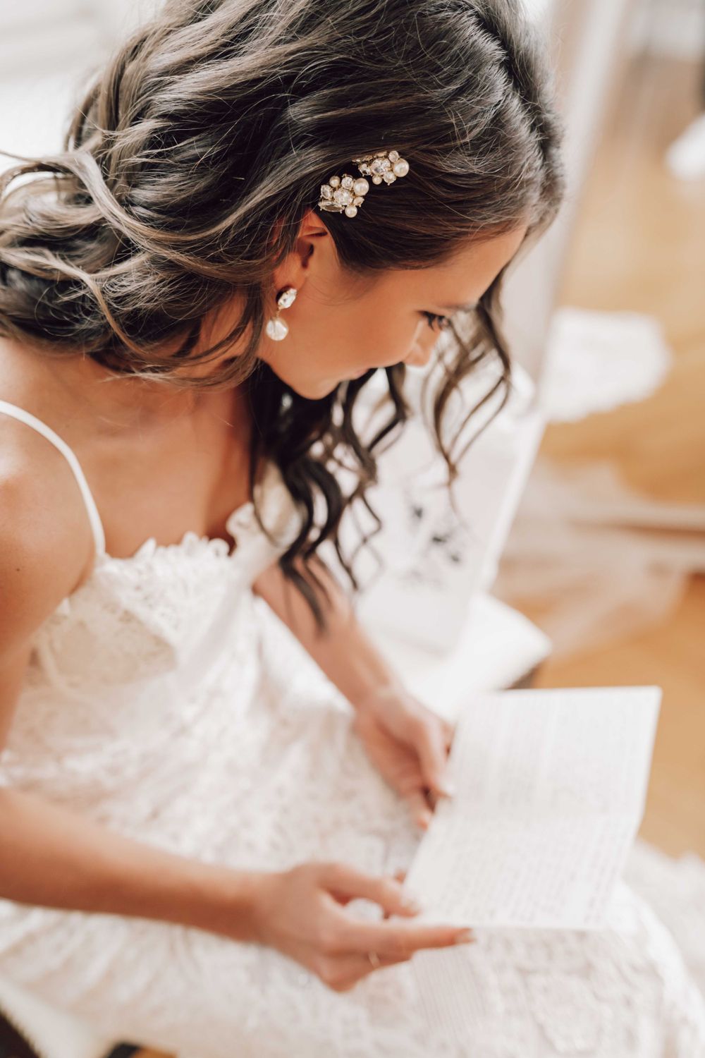 Close-up of delicate pearl hair accessories and white lace wedding dress details.