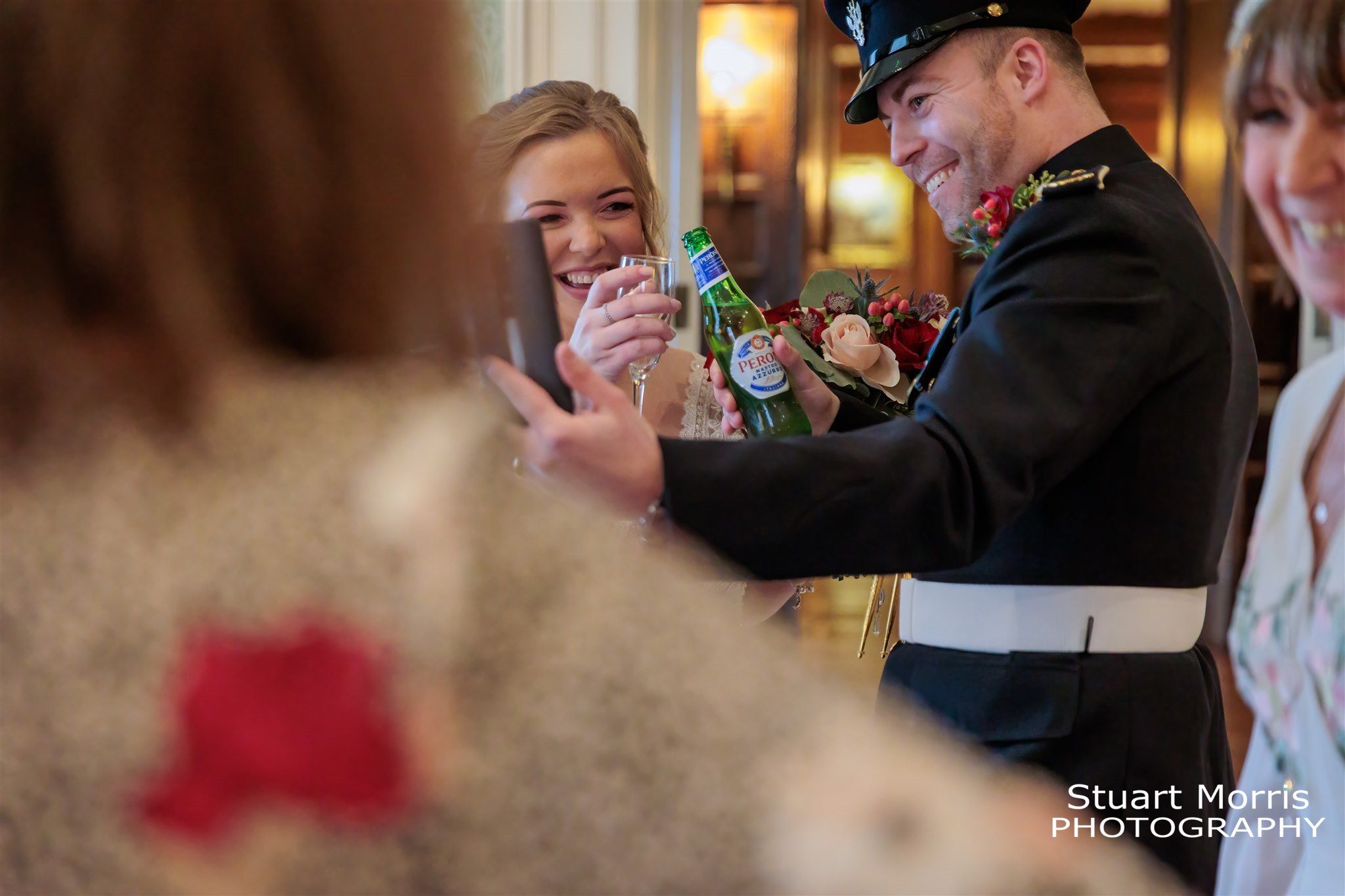 Groom shoes a smiling bride a photograph on  his phone.  Knowsley hall wedding photographer