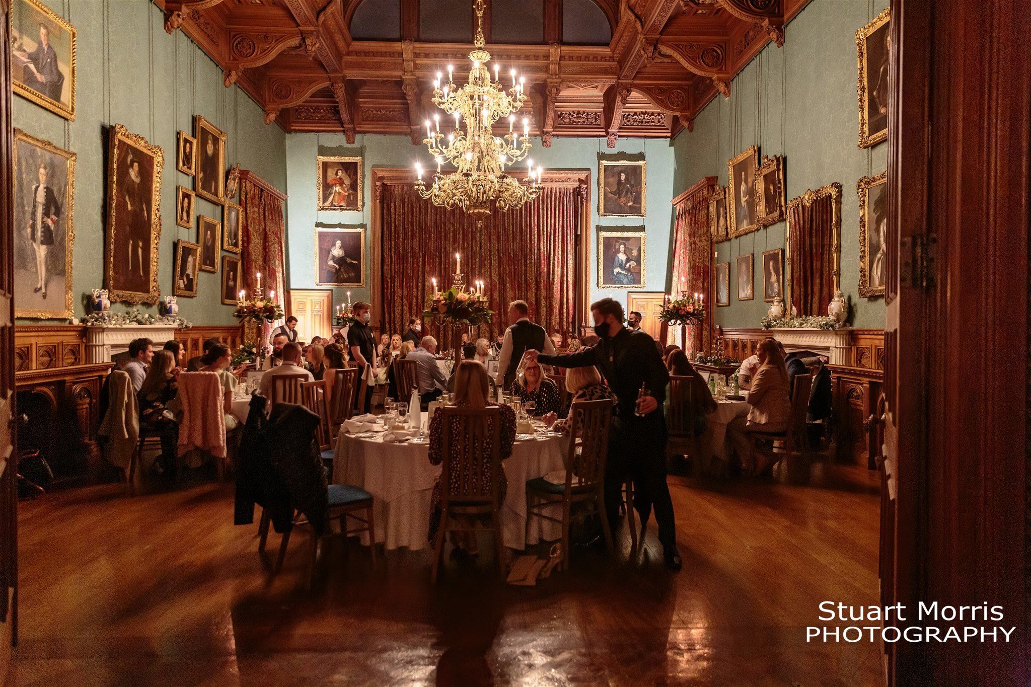 Wide shot of the guests enjoying the wedding breakfast in the dining room at Knowsley hall.