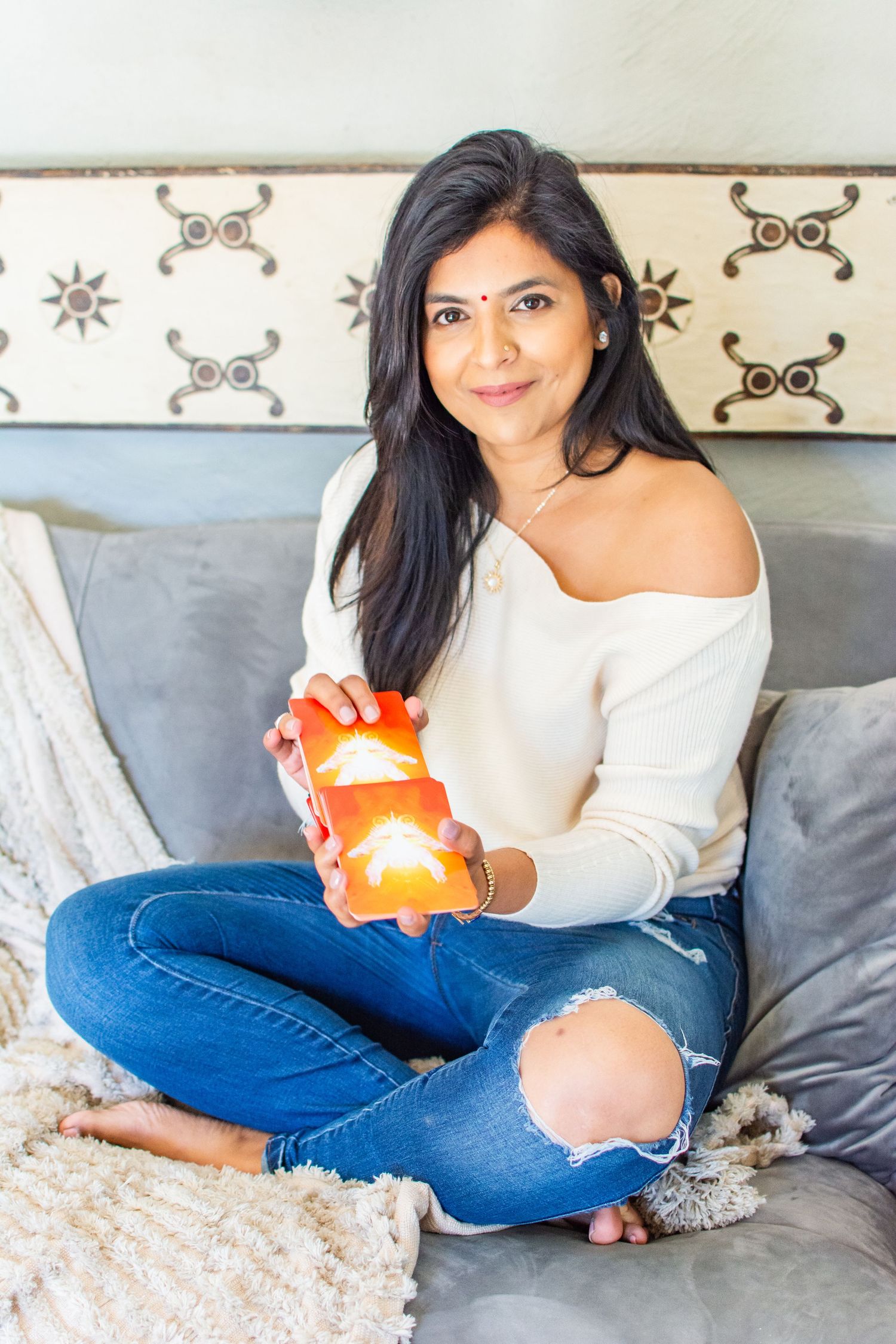 Relaxed lifestyle photo showing person on couch holding orange candles.
