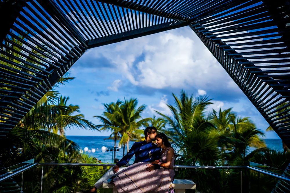 Geometric pergola frames tropical ocean view with palm trees and blue sky.