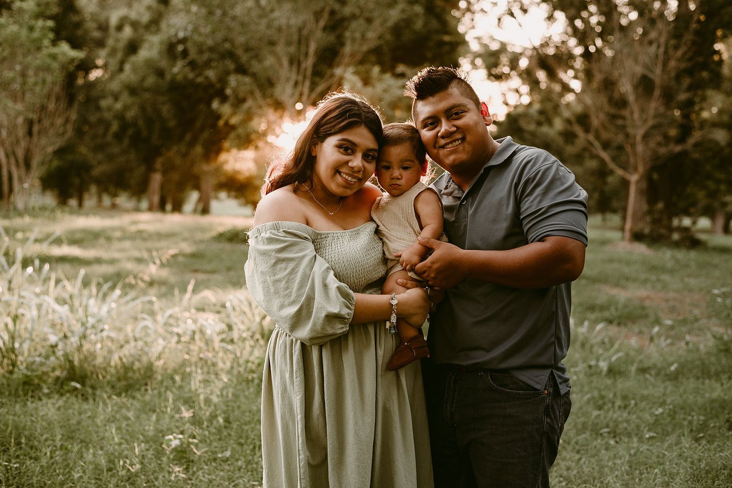 A loving family portrait captured in warm evening light at a scenic park.