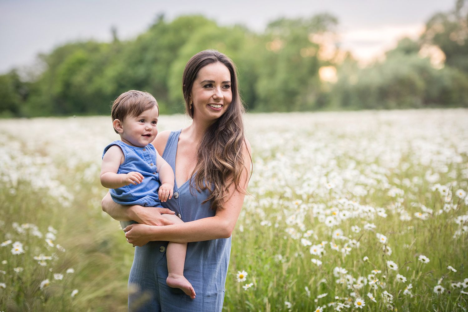 A tender moment captured in a field of white wildflowers at sunset.