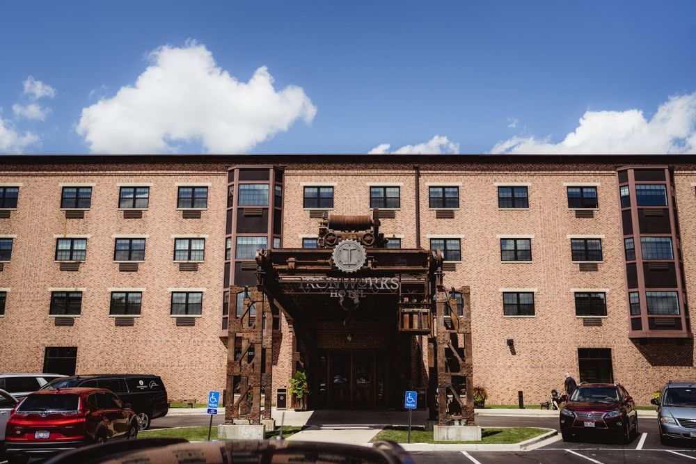 Exterior view of a brick hotel building with ornate entrance under blue sky.