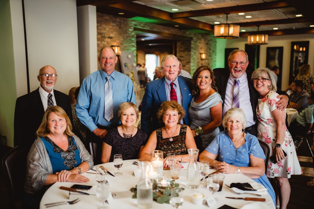A group gathers around a table at an elegant reception dinner.