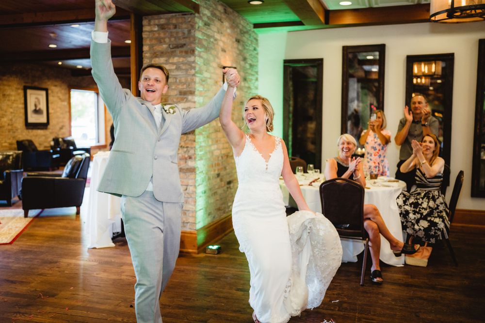 A celebratory entrance of a couple during a wedding reception.