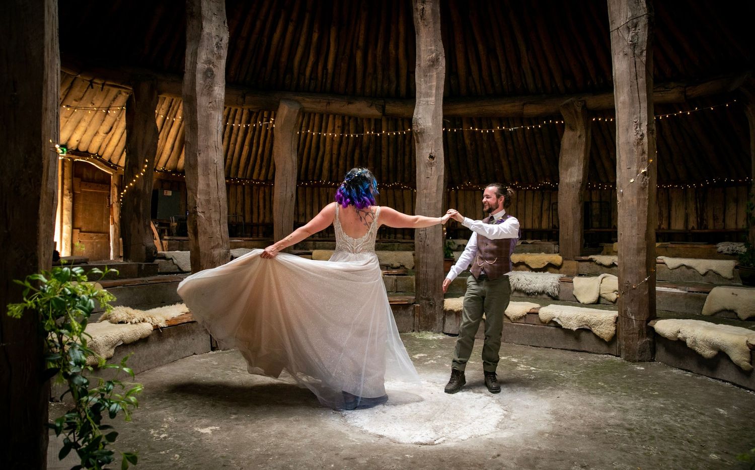Wedding dress twirling in motion inside a rustic wooden barn setting.