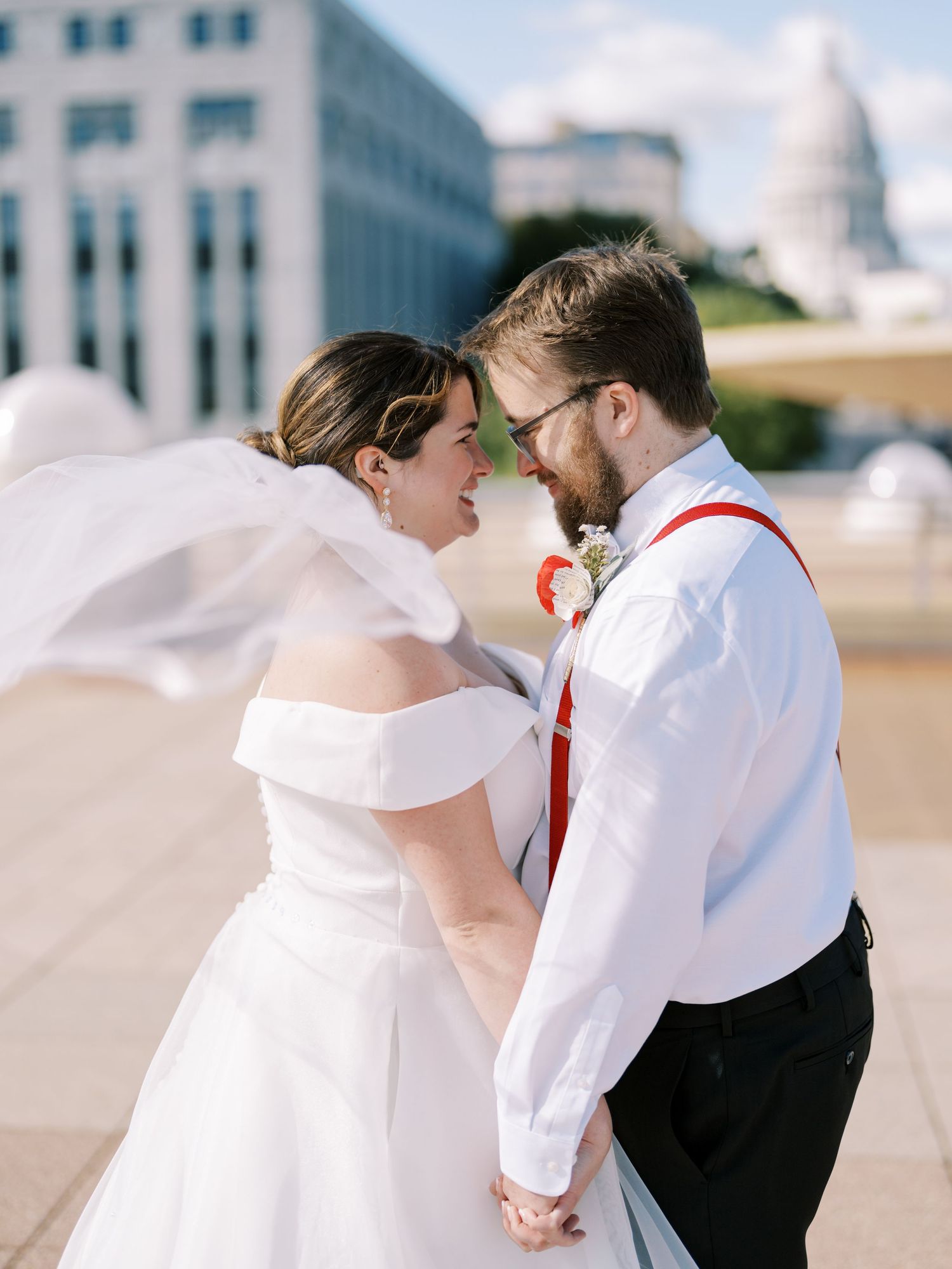 Wedding couple sharing intimate moment with Capitol building visible in background.